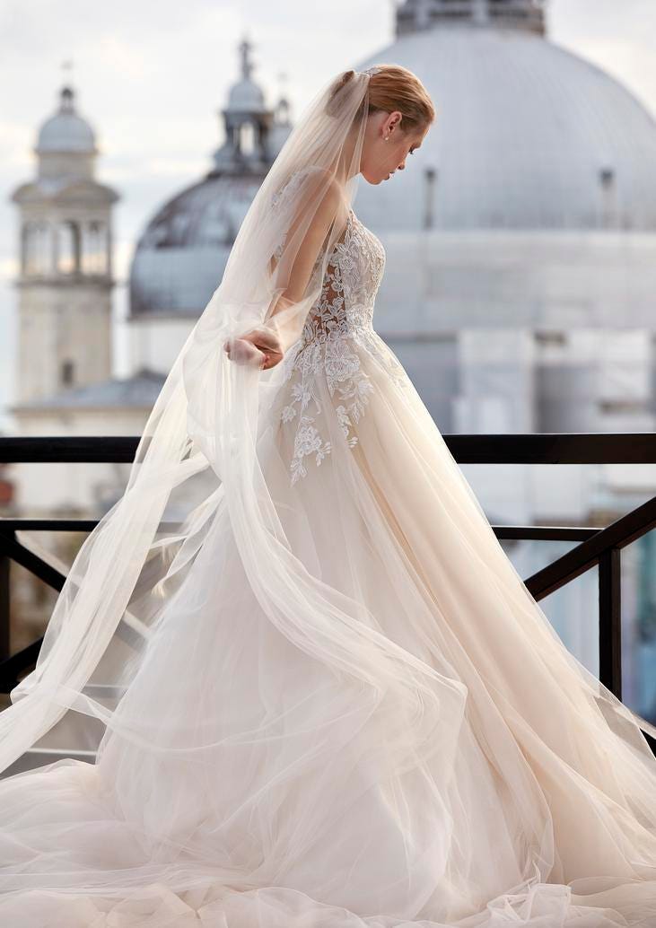 Sposa di profilo in una città italiana che indossa un abito da sposa principessa con gonna in tulle e corpetto in pizzo.